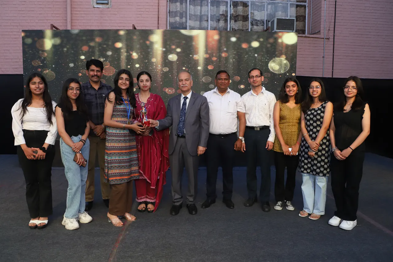 Award winners pose with guests in front of a glittering backdrop