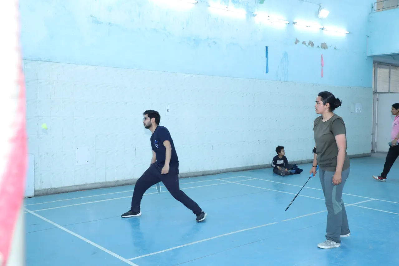 Mixed doubles players in a rally on the indoor badminton court