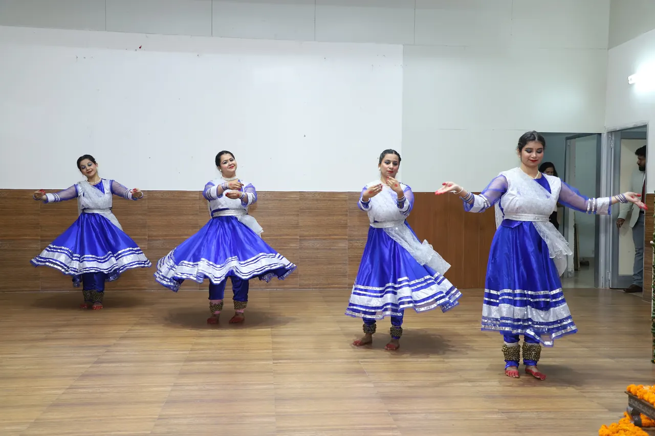 Dancers in blue and white perform in the auditorium