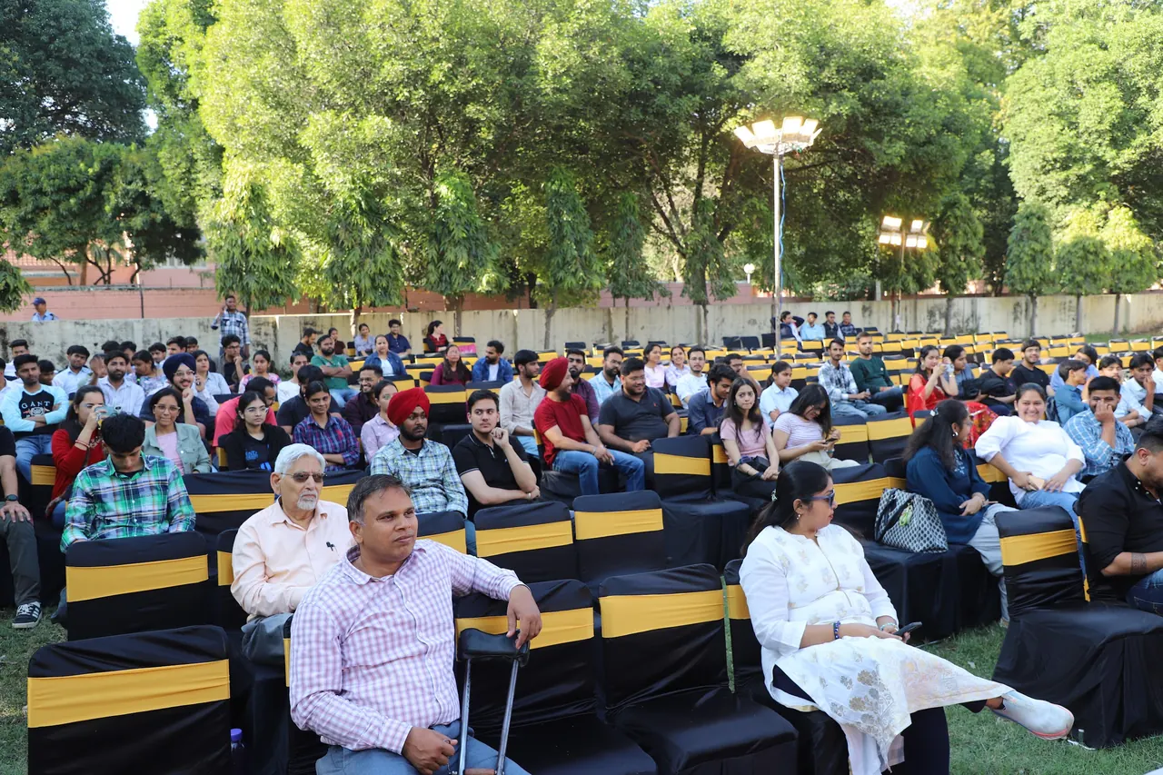 An audience seated on the lawn at the cultural programme