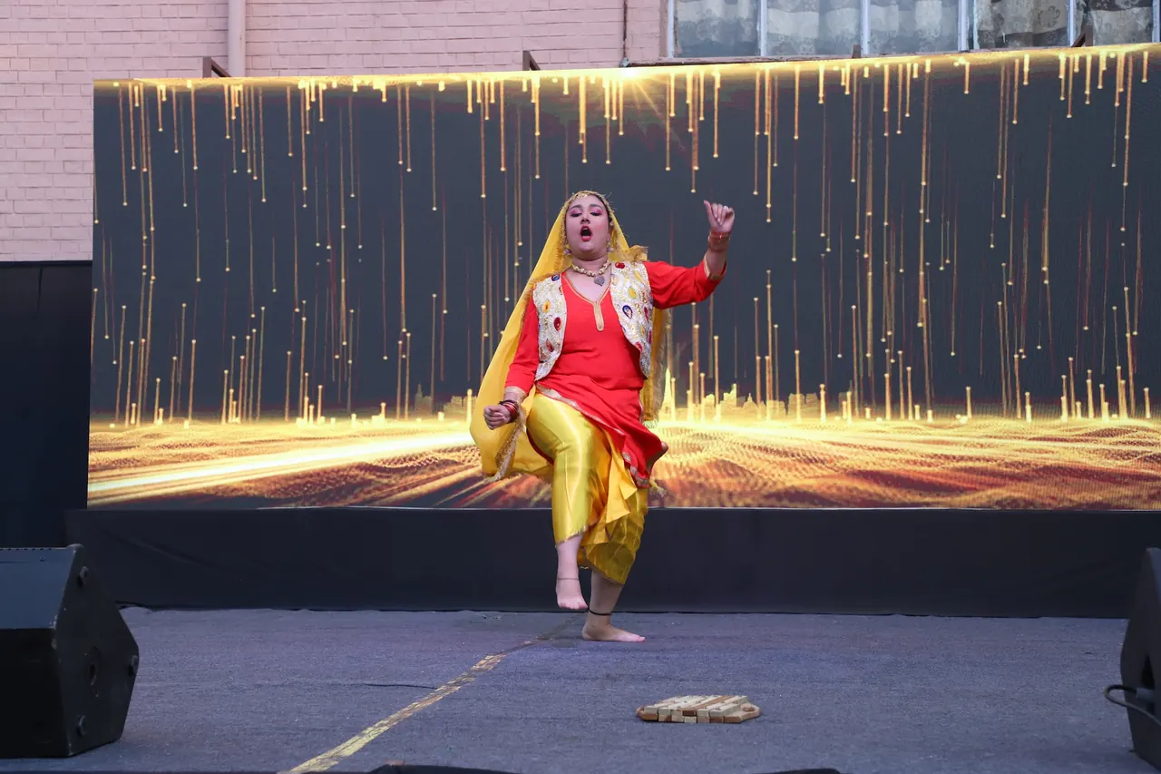 A dancer in yellow and red performs a folk dance
