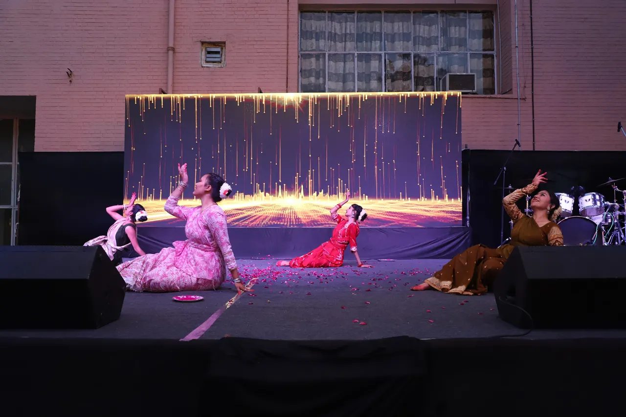 Dancers kneel and pose at the end of a performance