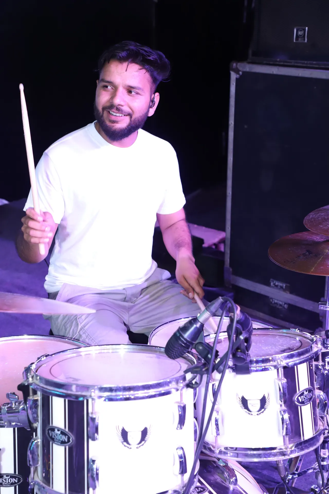 A drummer smiles behind his kit