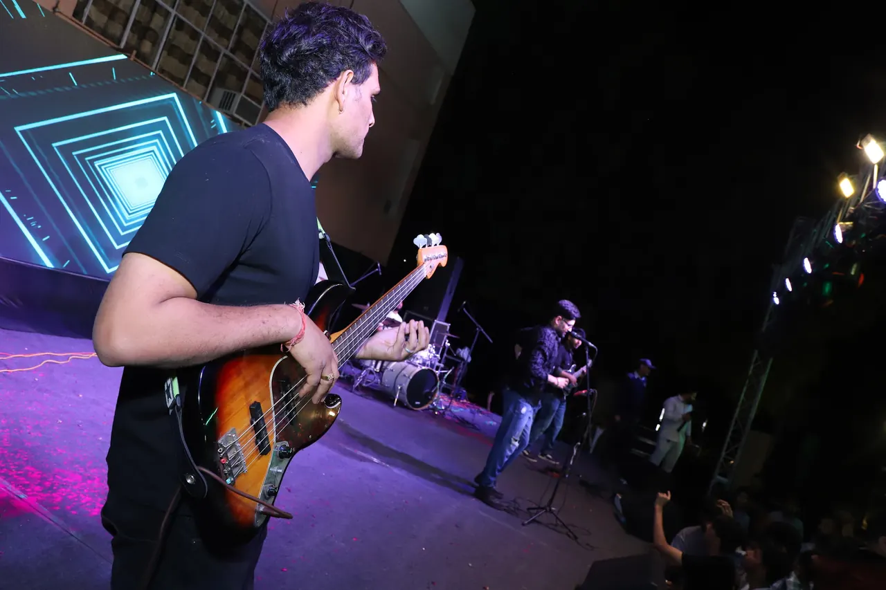 A bassist plays on a stage lit in purple
