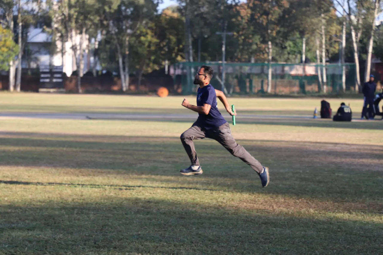 A sprinter runs across the sports ground