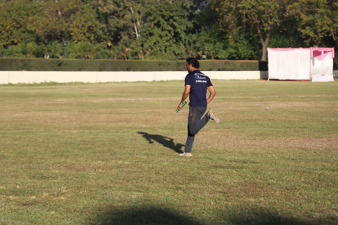 An athlete sprints on the grass track