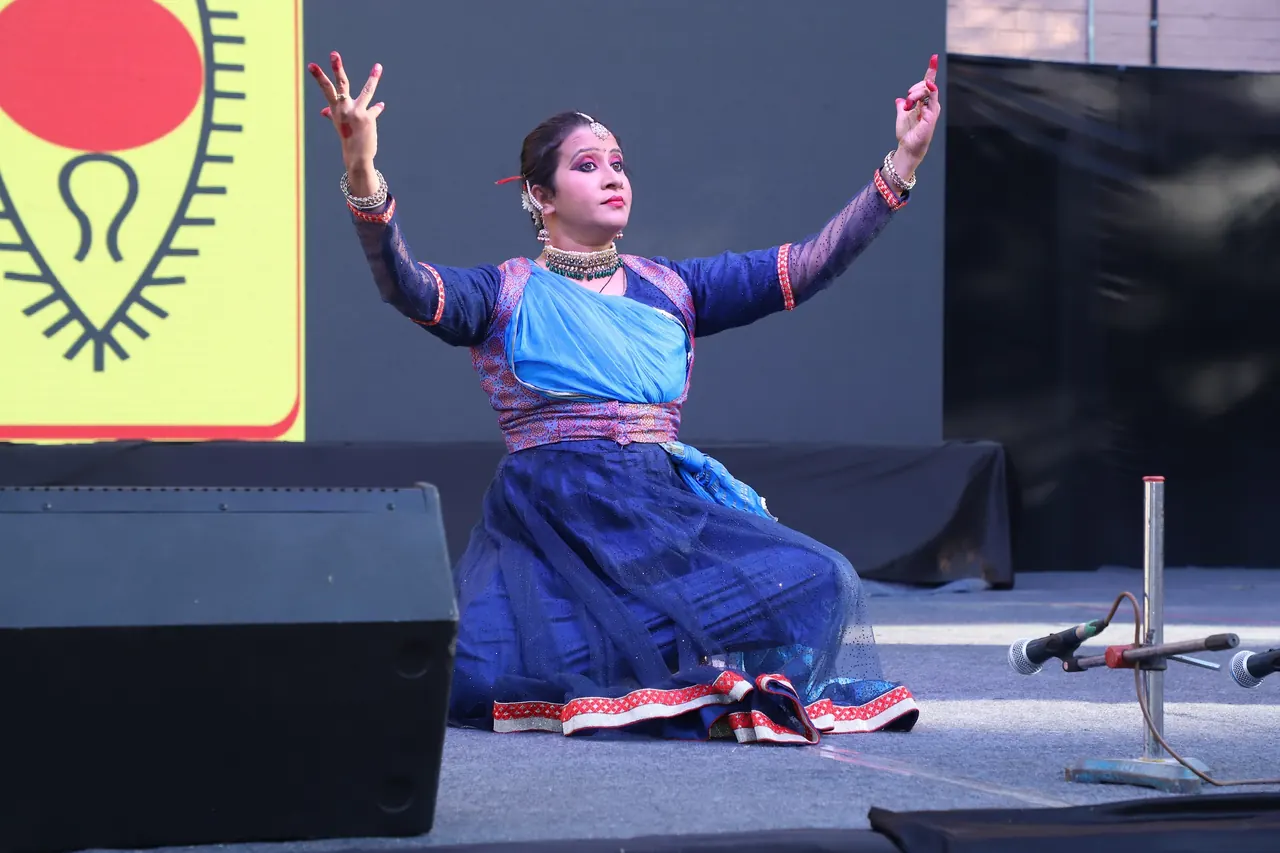 A classical dancer in blue strikes a pose on stage