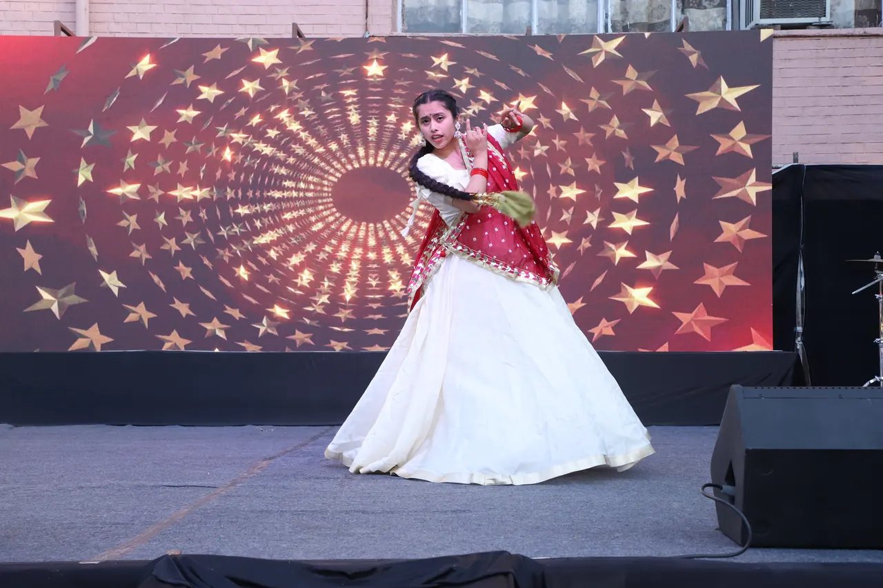 A dancer performs in front of a star-patterned LED backdrop
