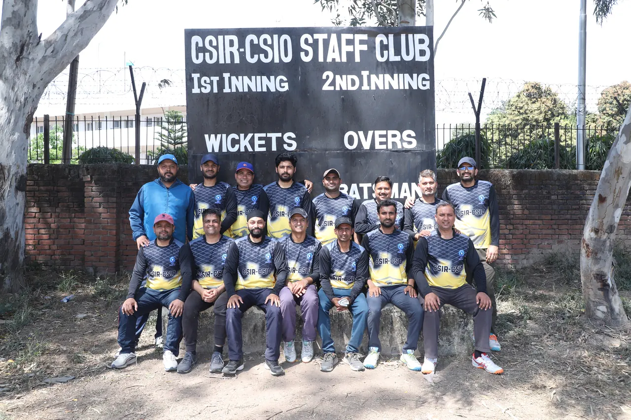 A cricket team poses in front of the CSIR-CSIO Staff Club scoreboard
