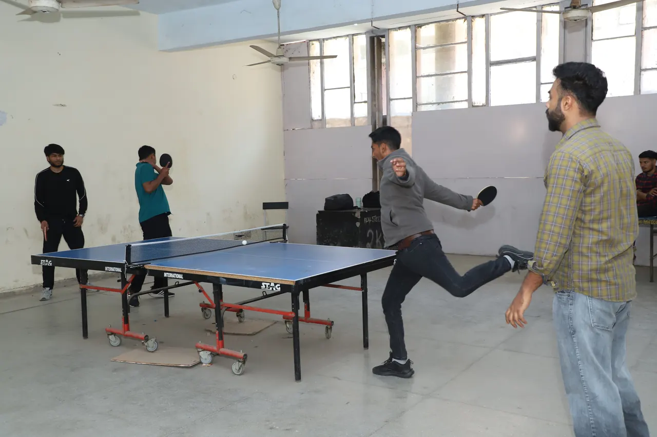 A table tennis player lunges for a return during a match