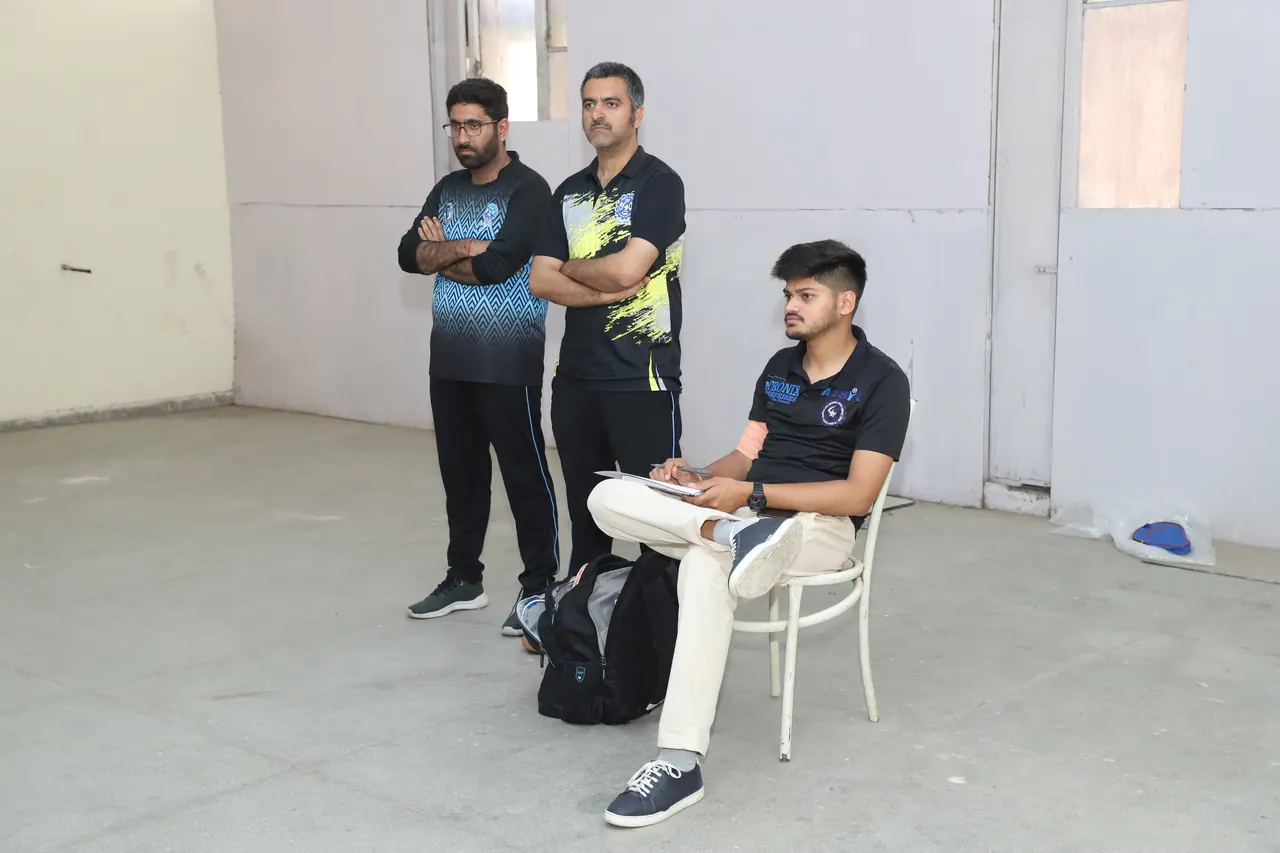 Officials keep score beside the table tennis tables