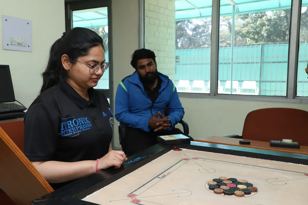 A player lines up a shot on a carrom board