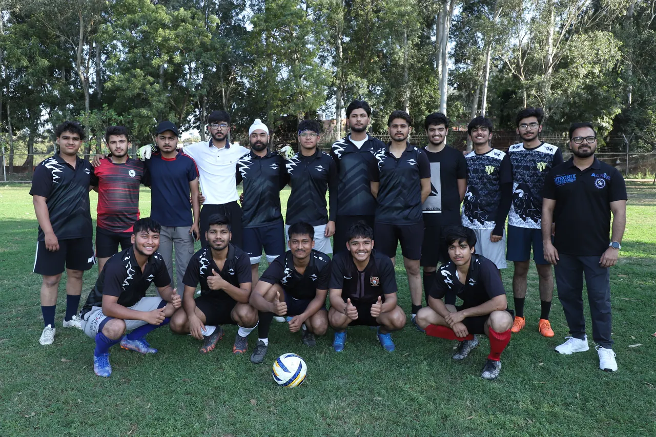 A football team poses for a group photograph on the field