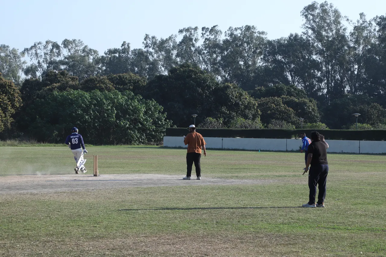 A batter runs between the wickets on the campus cricket ground