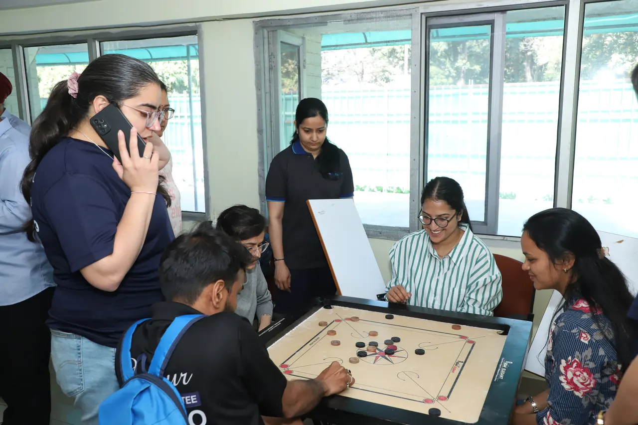 Participants gathered around a carrom game