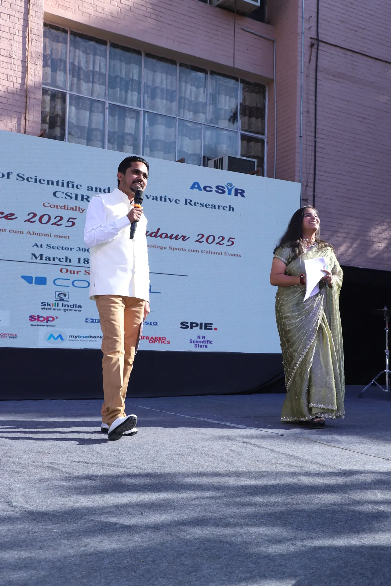 A speaker on stage in front of the event backdrop