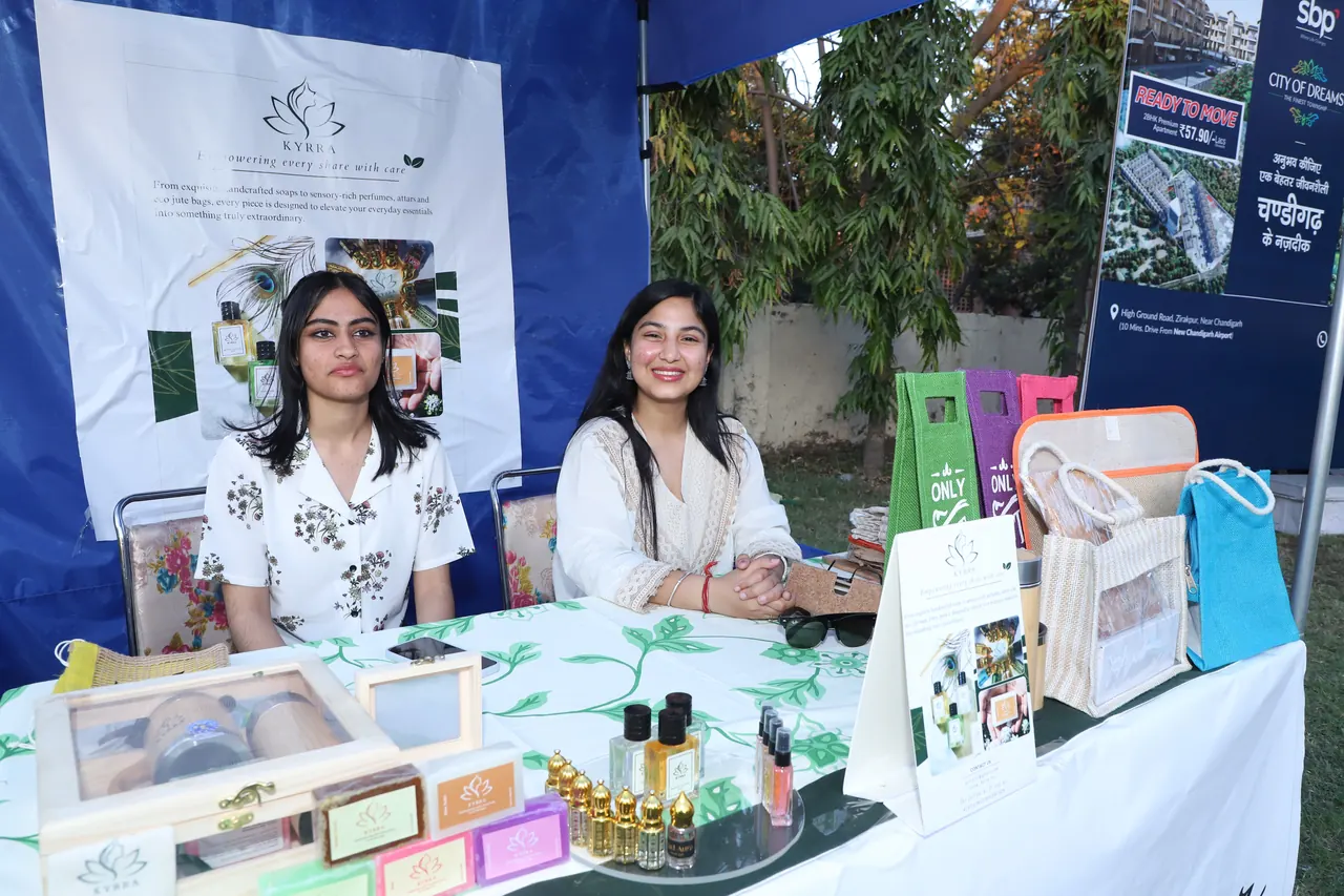 Two exhibitors smile behind a product stall at the event