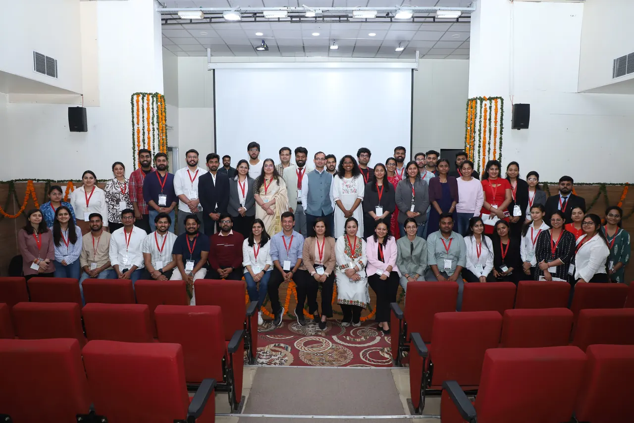Participants pose for a group photograph in the auditorium