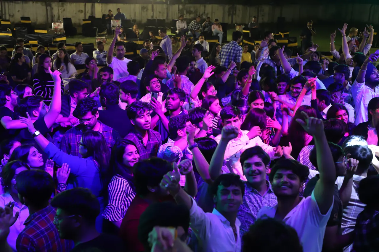 Students dance together under purple lights