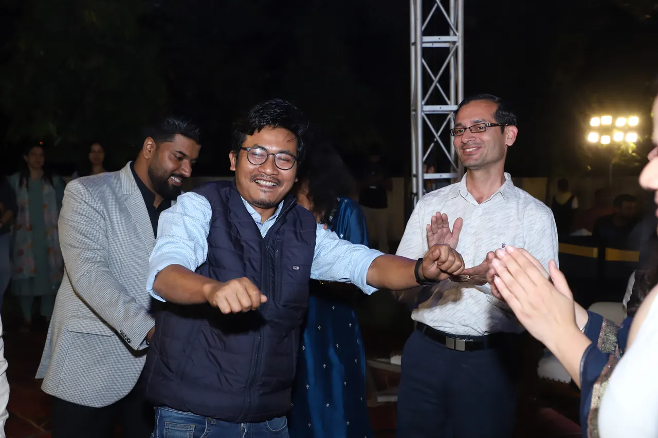 Faculty members dance with the crowd at the evening programme