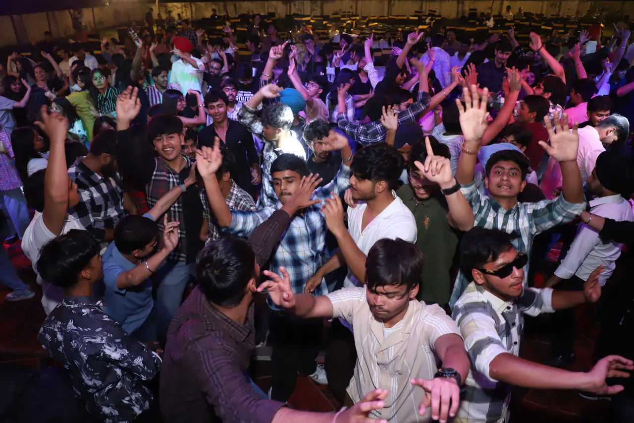 A packed crowd raises their hands at the evening programme