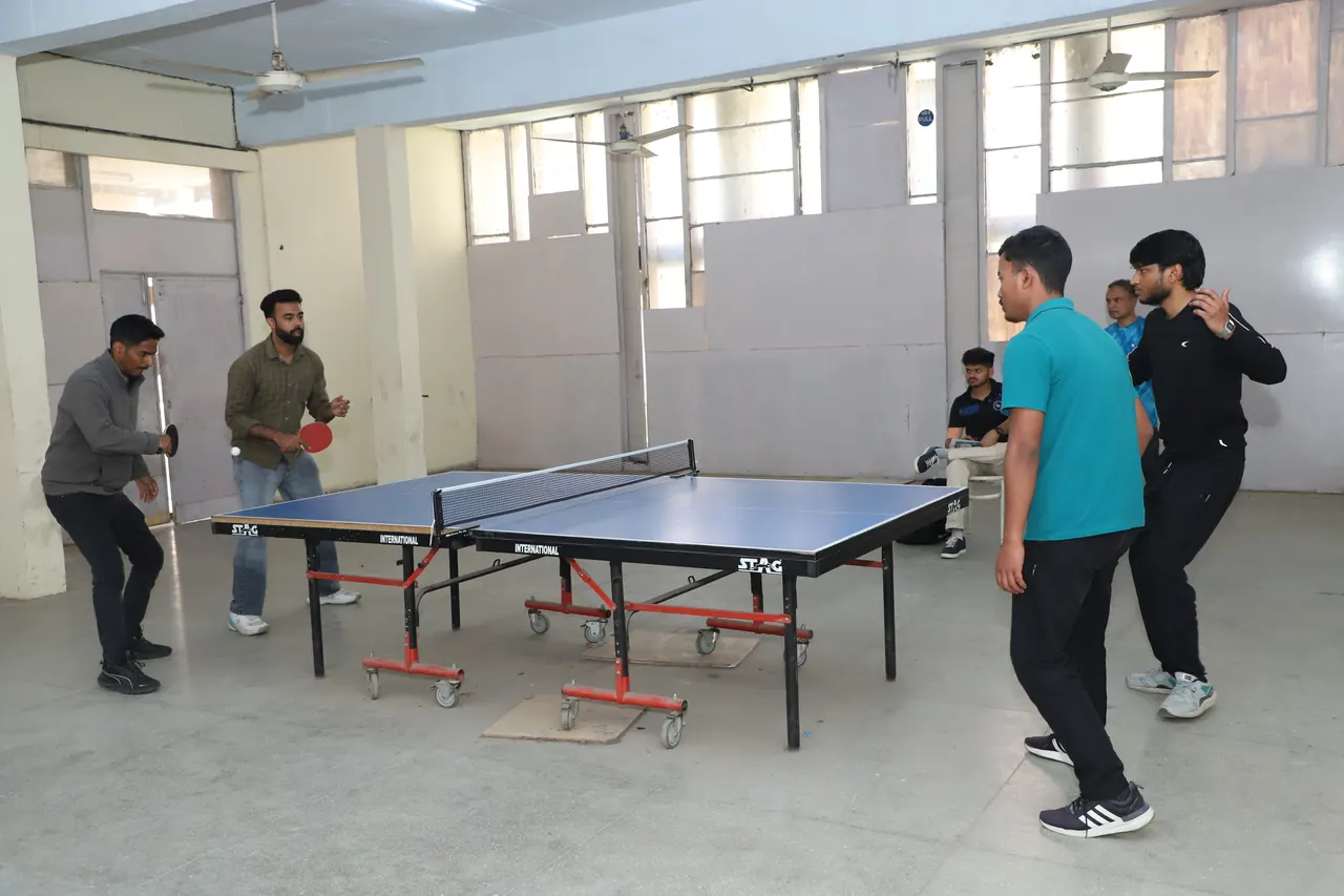 Players at the table tennis tables in the indoor hall