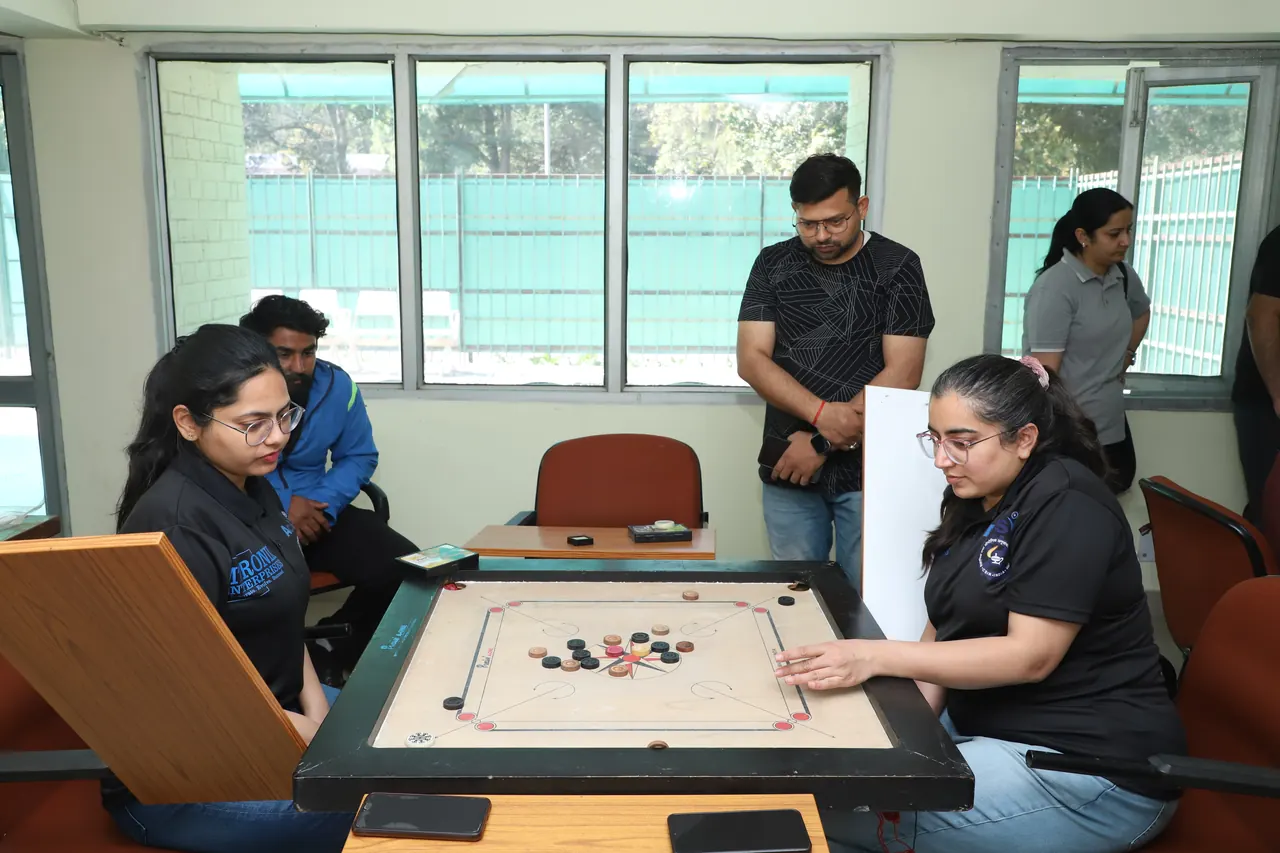 Two players concentrate on a carrom game