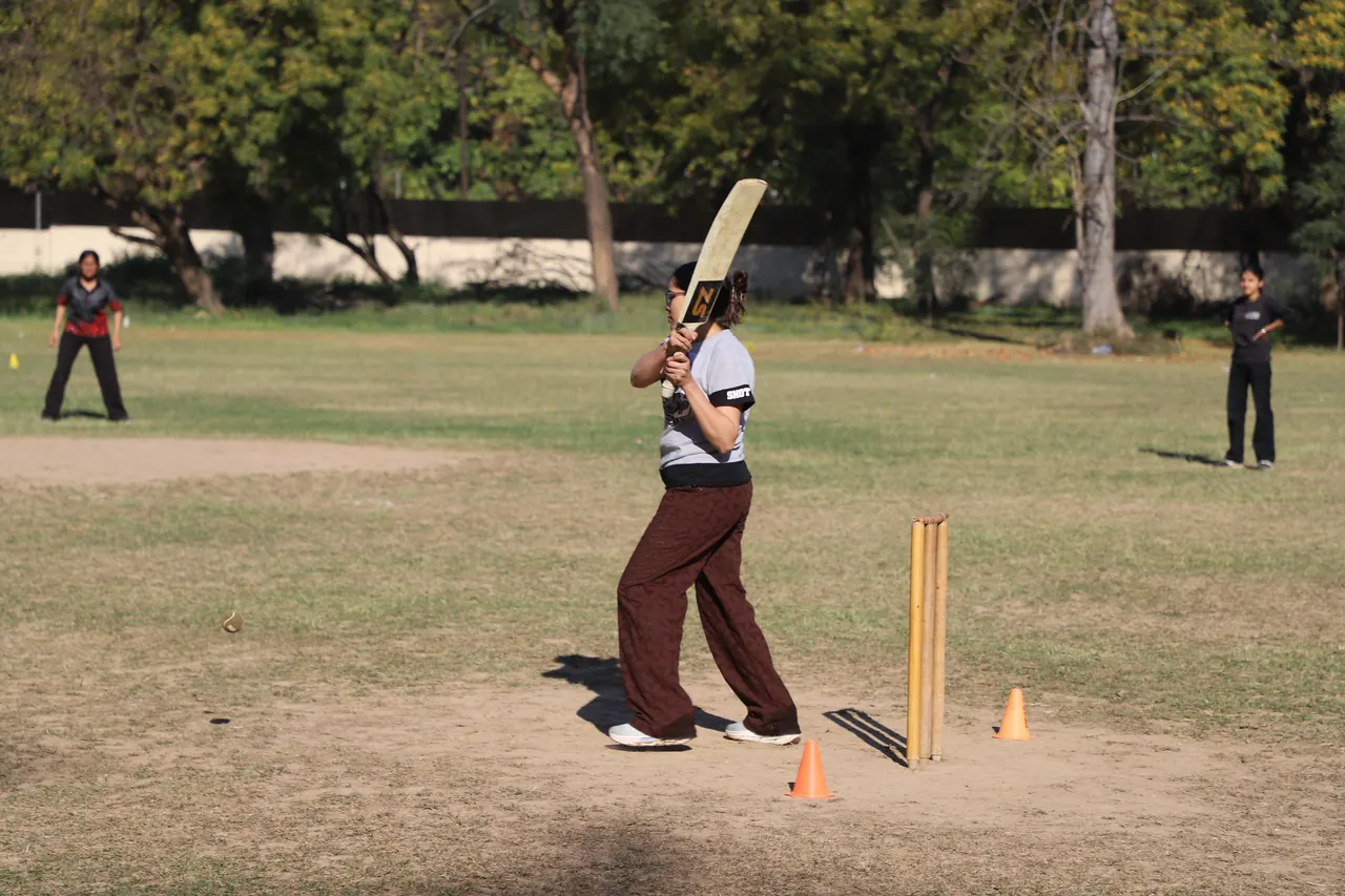 A batter takes guard in front of the stumps