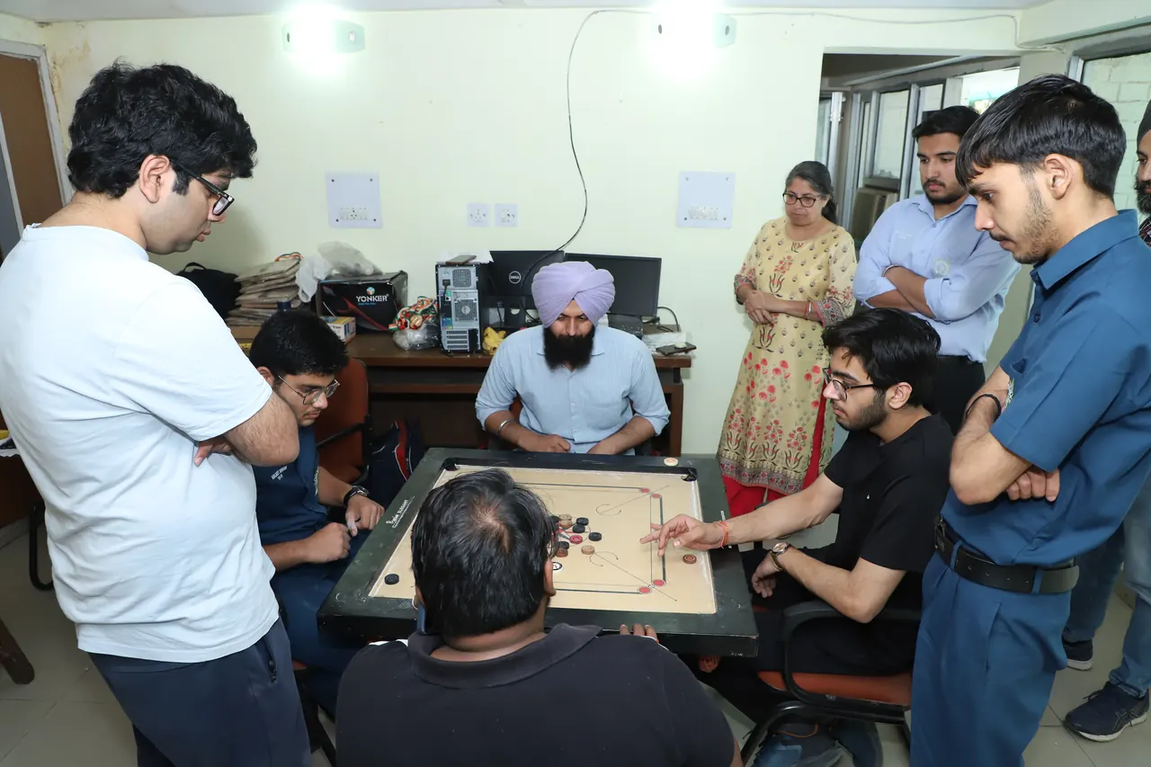 Onlookers gather around a carrom game