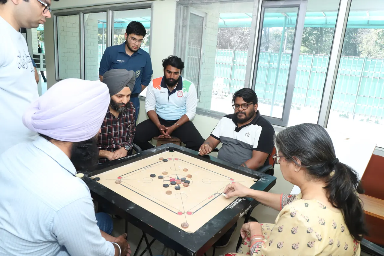 Players and spectators around a carrom board