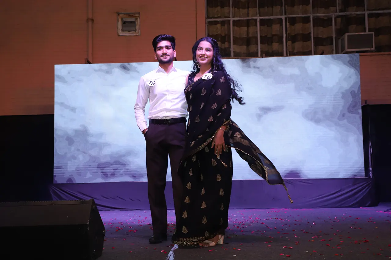 Two participants pose on the ramp in front of a cloud backdrop