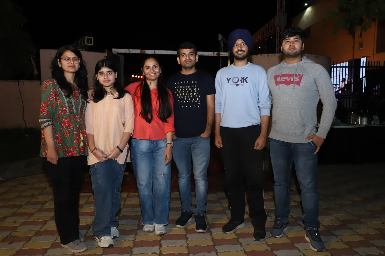 A group of participants poses together at night