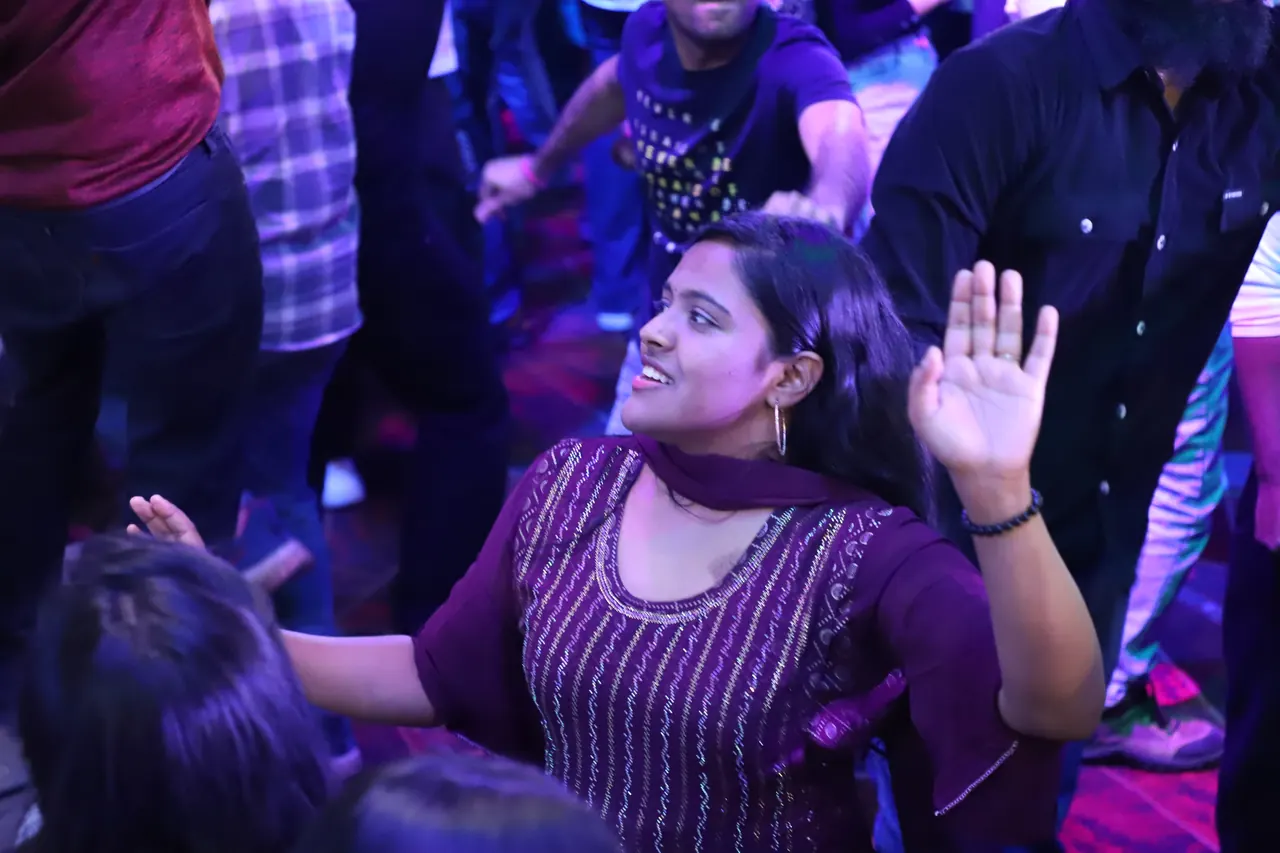 A participant dances in the crowd at night