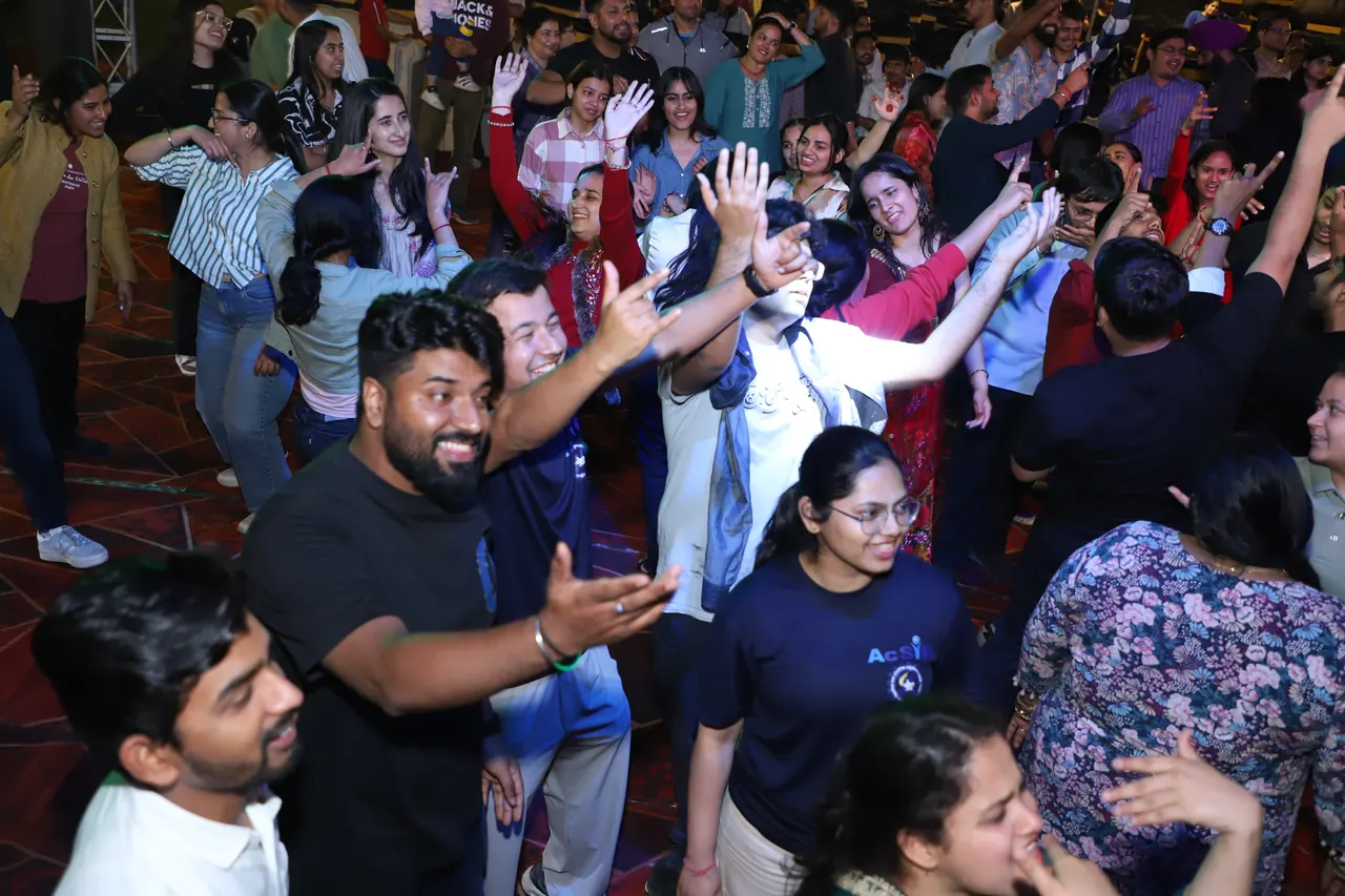A crowd dances and laughs together