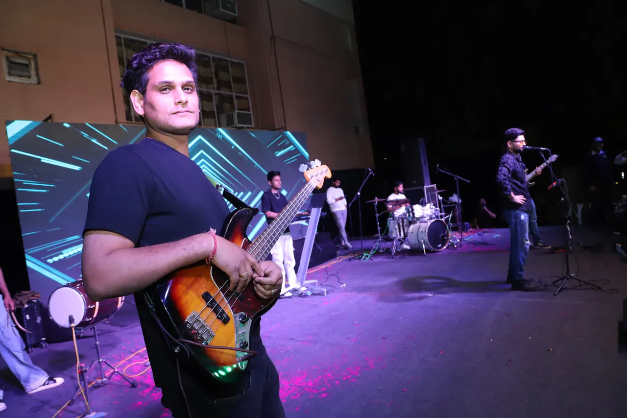 A bassist plays on a stage lit in purple