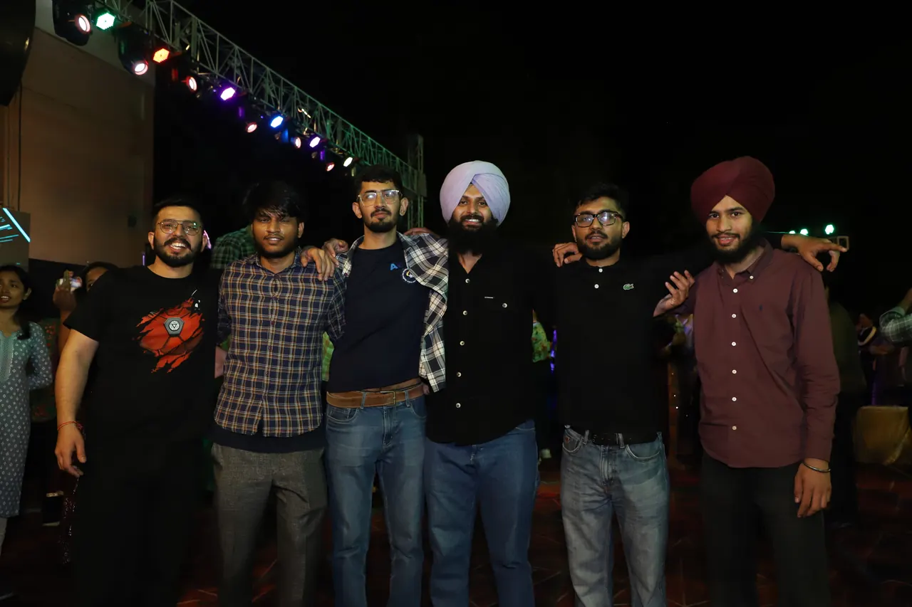 Friends pose together under the stage lights