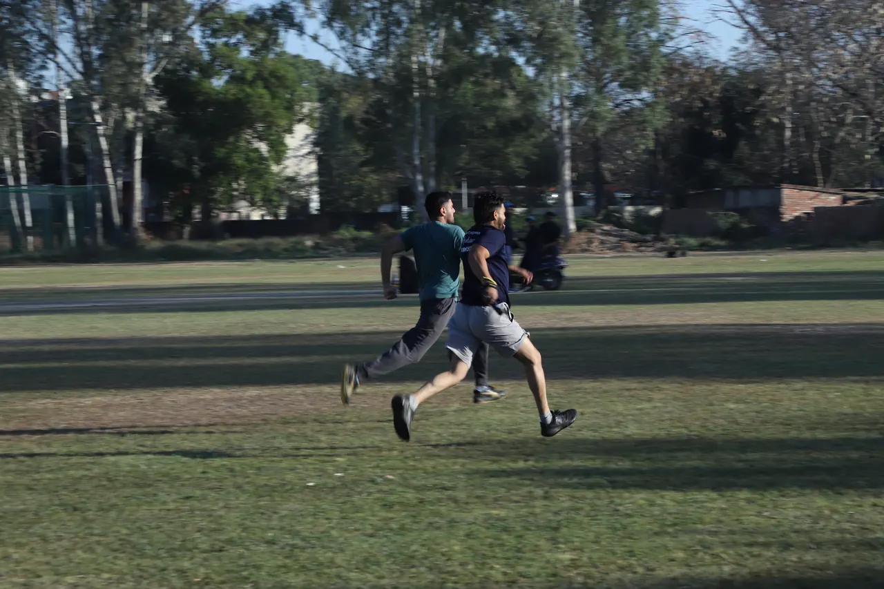 Two runners sprint across the grass