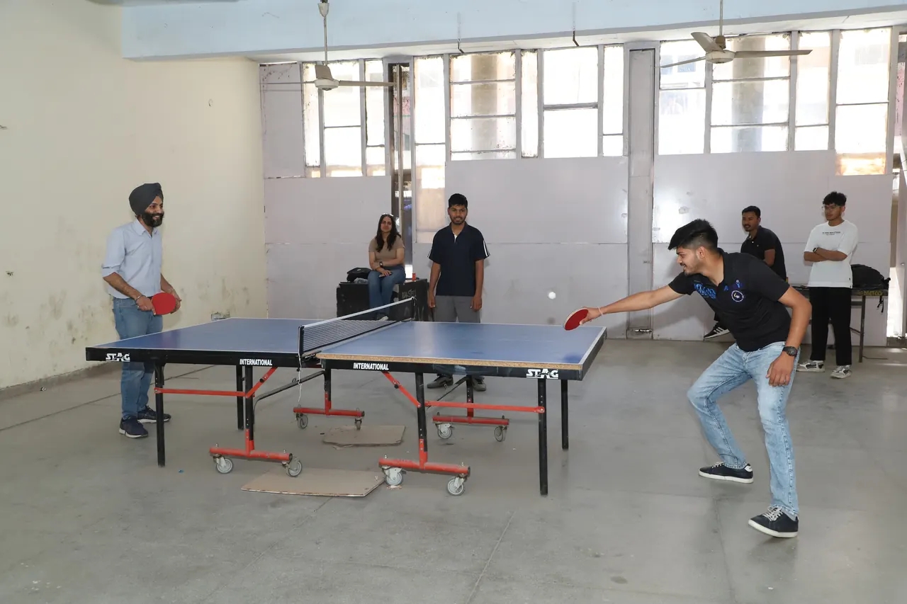 A table tennis player reaches for the ball across the table