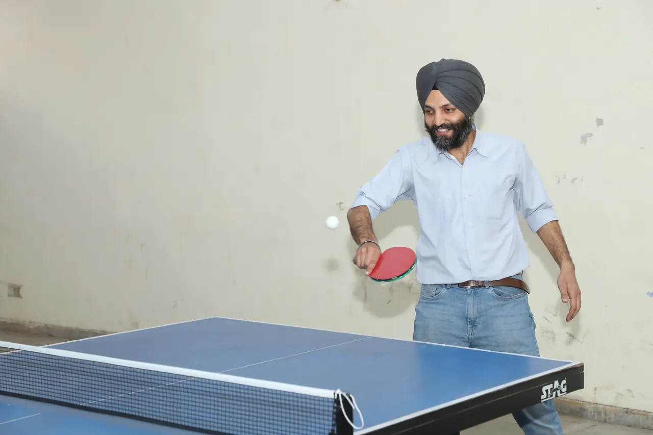 A table tennis player in a turban plays a shot