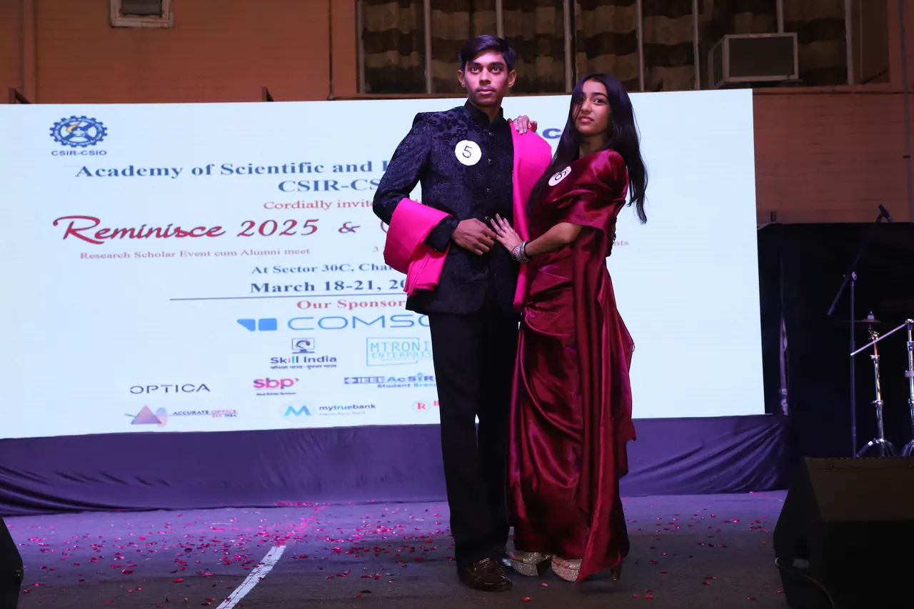 Two participants in formal wear pose together on the ramp