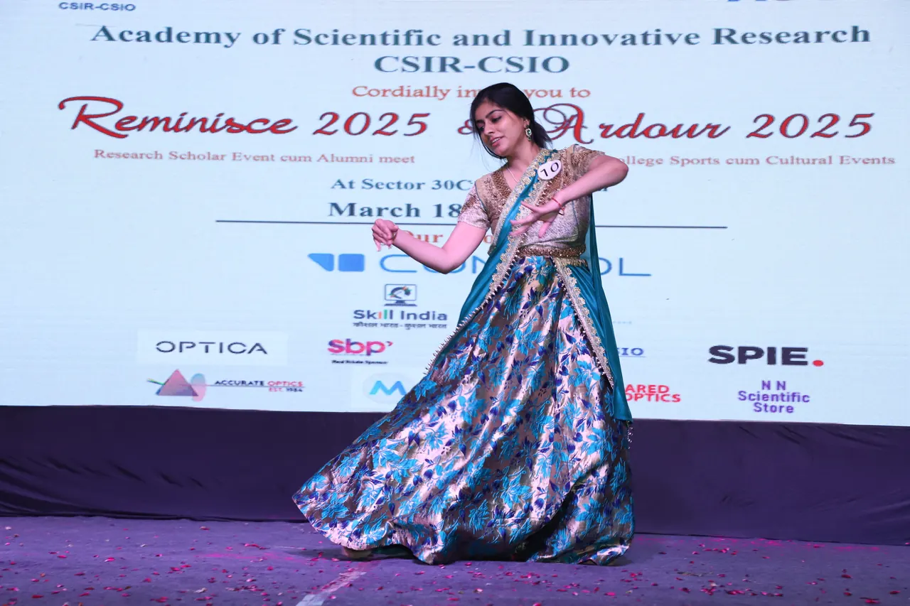 A participant in a peacock-print lehenga strikes a pose on stage
